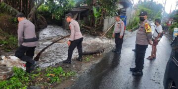 Bhabinkamtibmas Membantu Evakuasi SPM Korban Banjir di Desa Bebandem