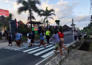Personil Polsek Rendang Pos Pagi Atensi Anak Sekolah Menyeberang Jalan