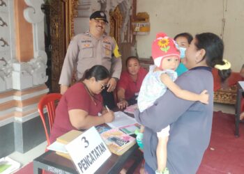 Dukung Kesehatan Anak, Bhabinkamtibmas Dampingi Pelaksanaan Kegiatan Posyandu dan Pemberian Obat Cacing