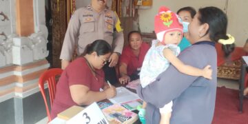 Dukung Kesehatan Anak, Bhabinkamtibmas Dampingi Pelaksanaan Kegiatan Posyandu dan Pemberian Obat Cacing
